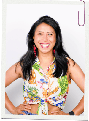 Confident personal finance coach smiling in a tropical blouse, empowering women to achieve financial independence.